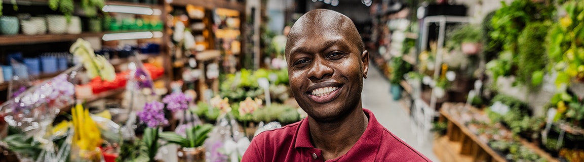Man standing in shop with goods in background