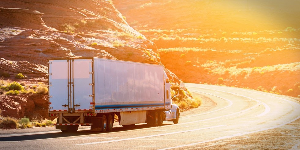 Truck driving at sunset on highway