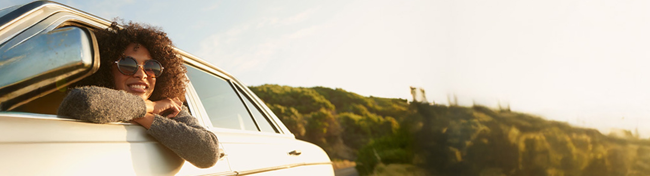 happy woman leaning out of car window