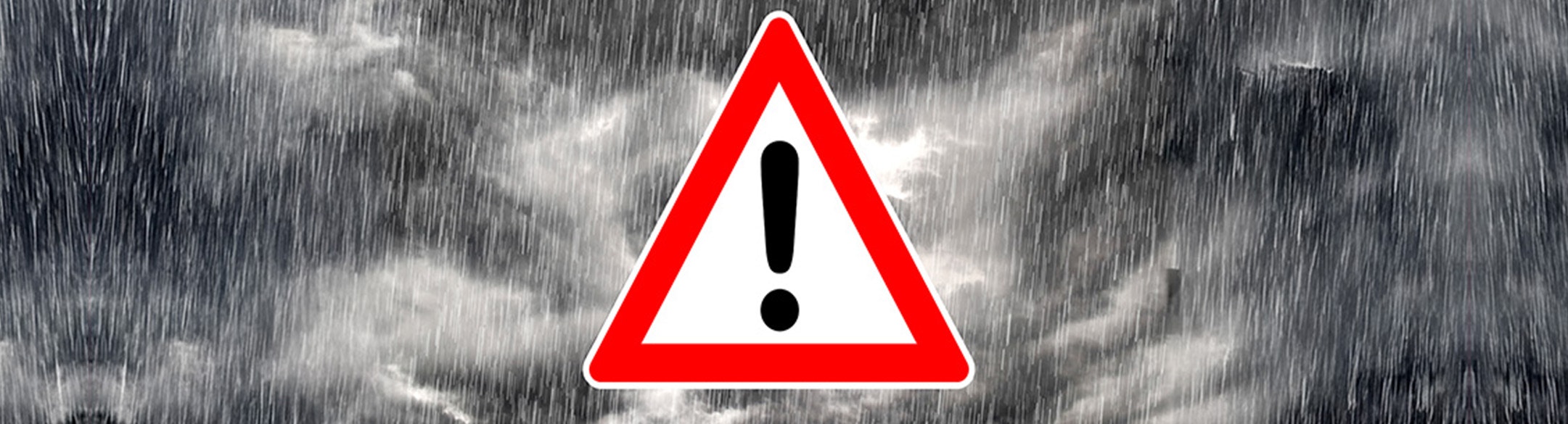 warning triangle on a picture of stormy weather