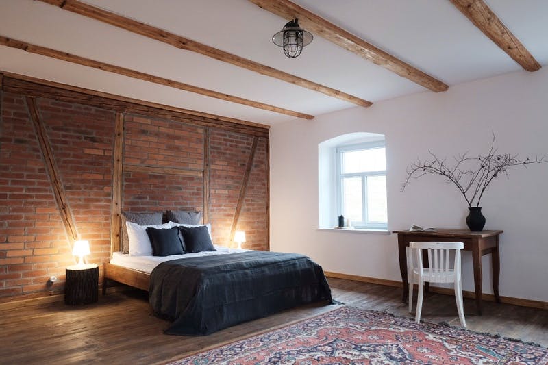 widok pokoju gościnnego; drewniane wykończenie, biały sufit i ściany; małe okno