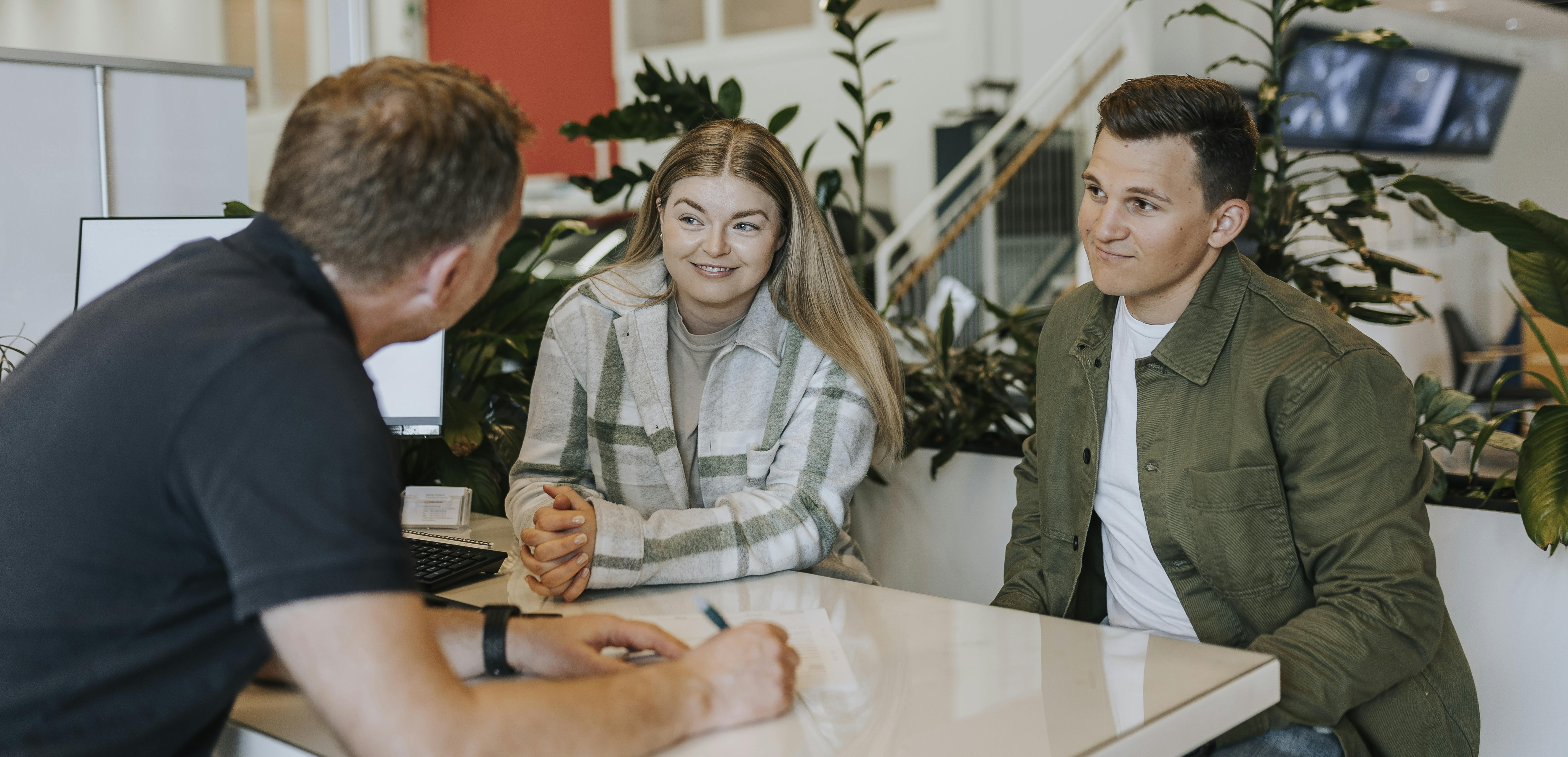 Couple at a table with a car dealer
