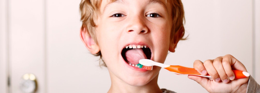 Un petit garcon qui se brosse les dents