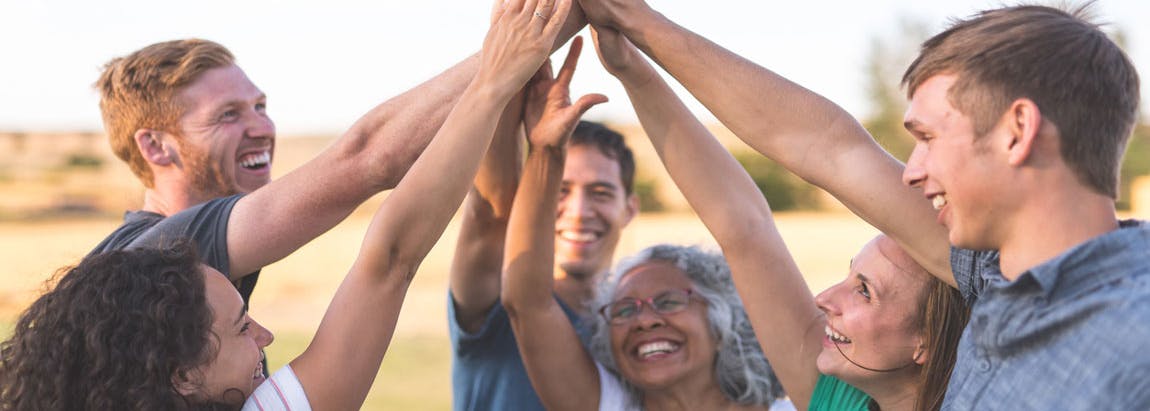 Groupe de personnes levant les bras et se touchant les mains