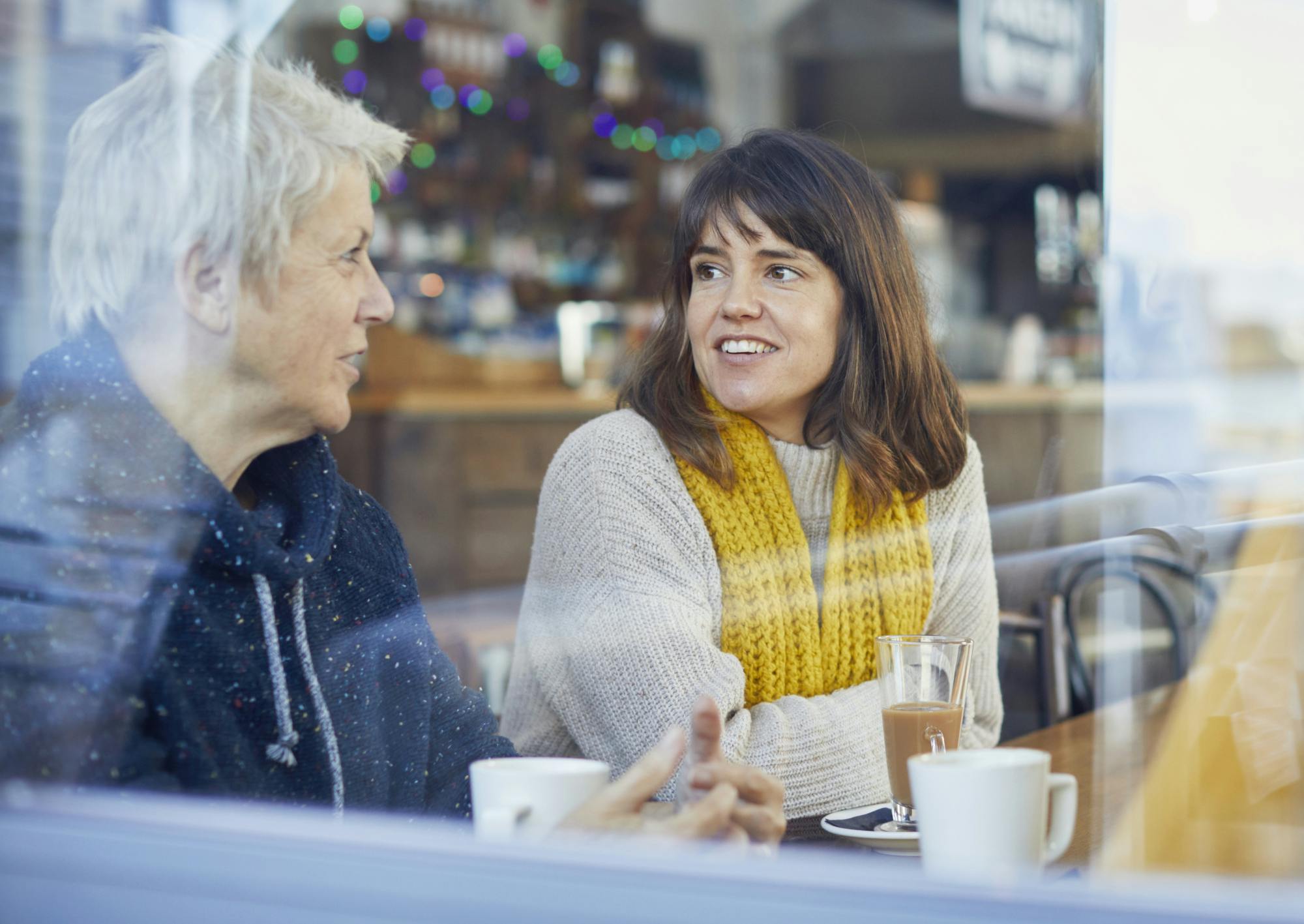 Deux femmes discutent de la ménopause autour d'un café.