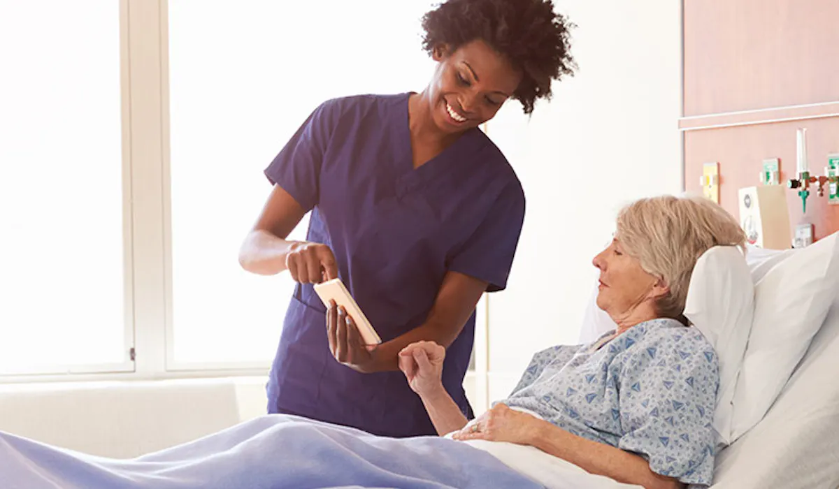 Femme dans son lit d'hopital avec une infirmiere