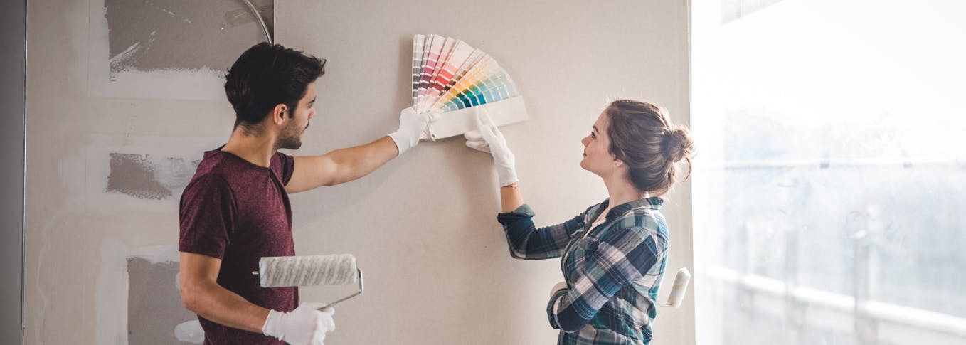 Un homme et une femme choisissent la couleur de la peinture d'un mur
