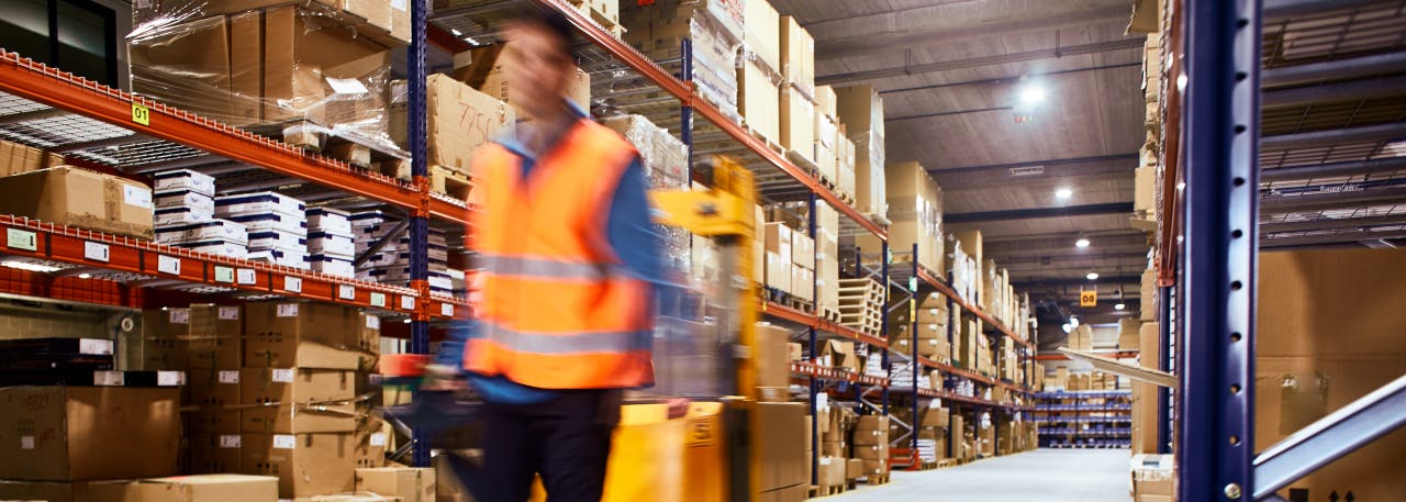 Un homme tirant un chariot dans un entrepôt