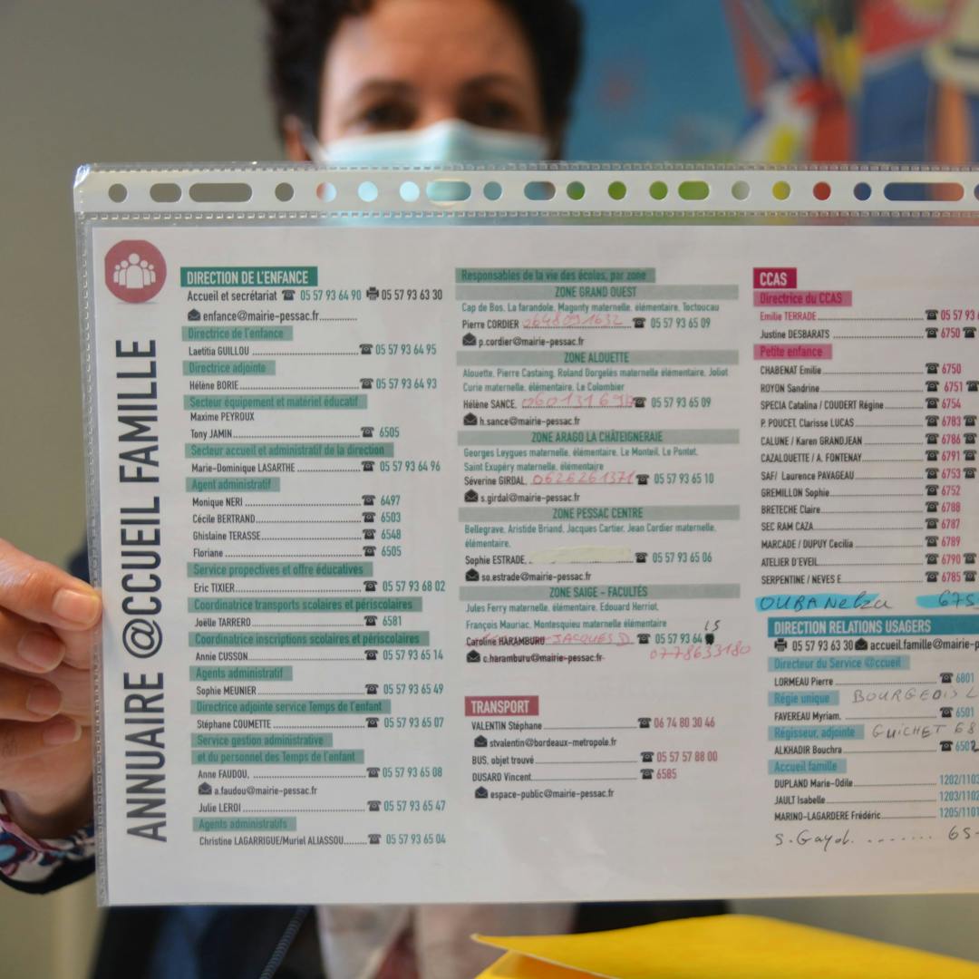 Un outil d'accueil en papier tenu par un agent
