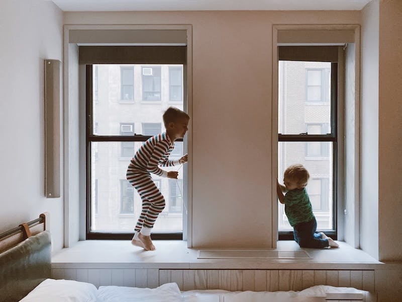 2 børn hopper i vindueskarmen