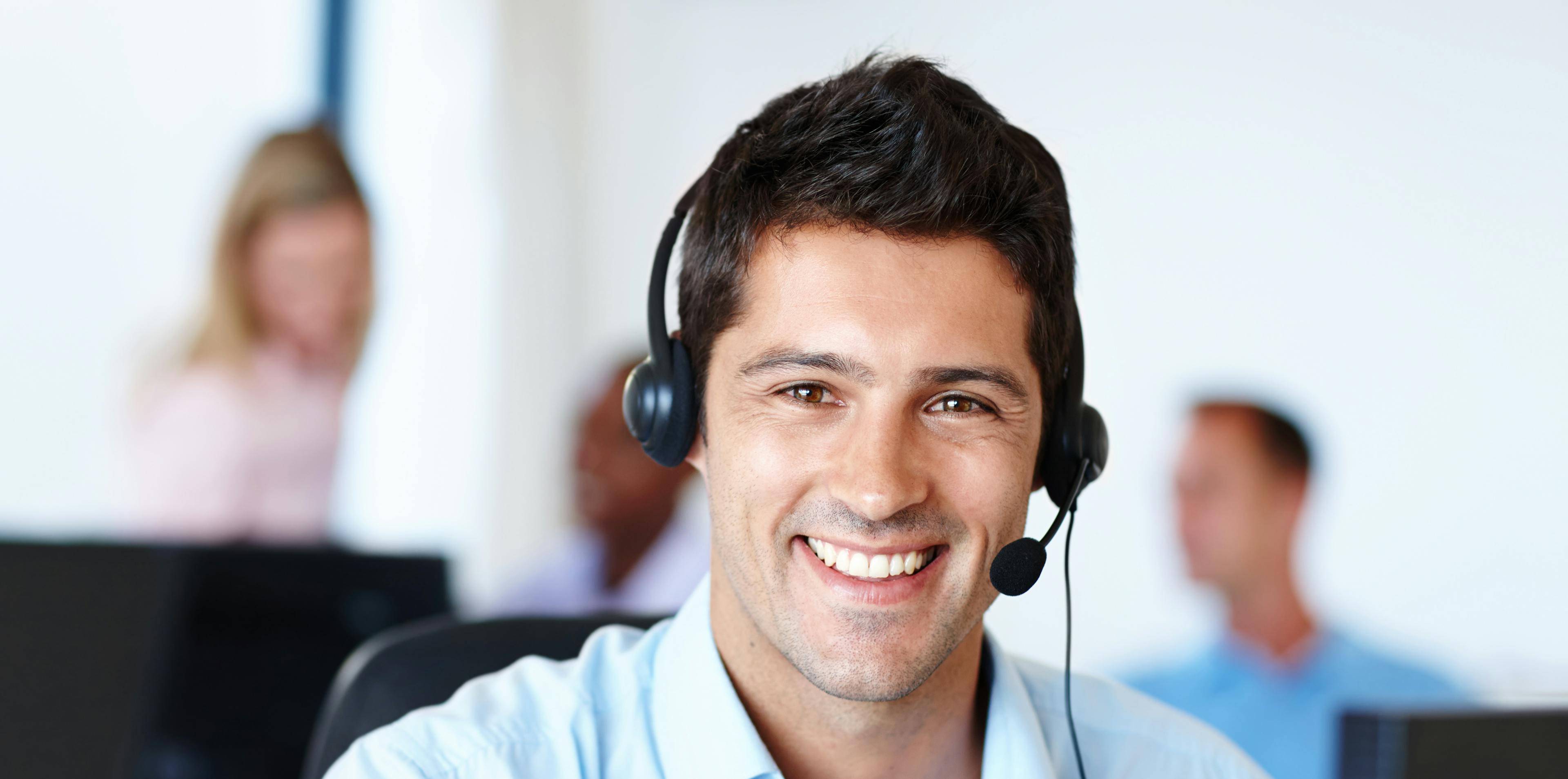 Mitarbeiter eines Callcenters mit Headset im Portrait