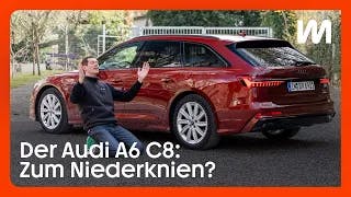 Peter R. Fischer kniet vo einem Audi A6 C8 