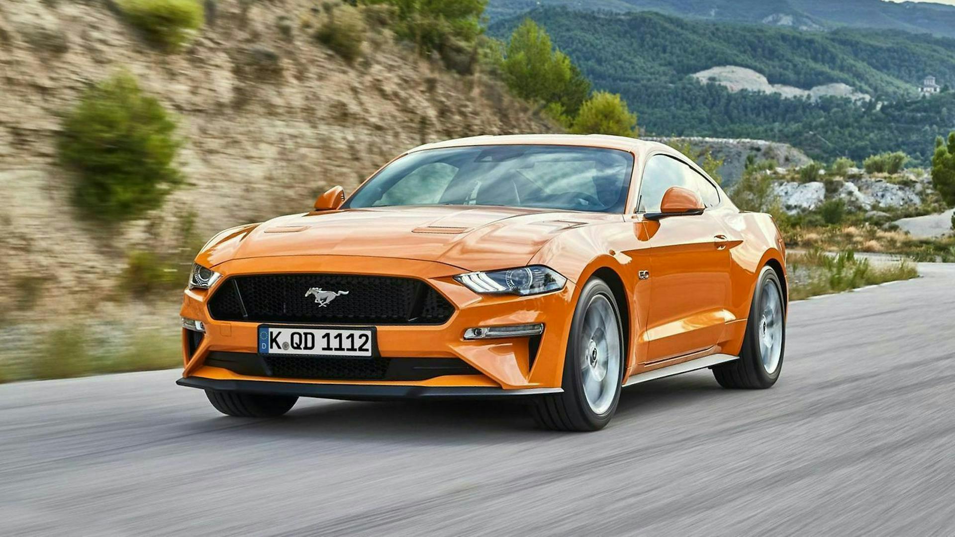 Ford Mustang 6 in Orange fährt auf einer Landstraße