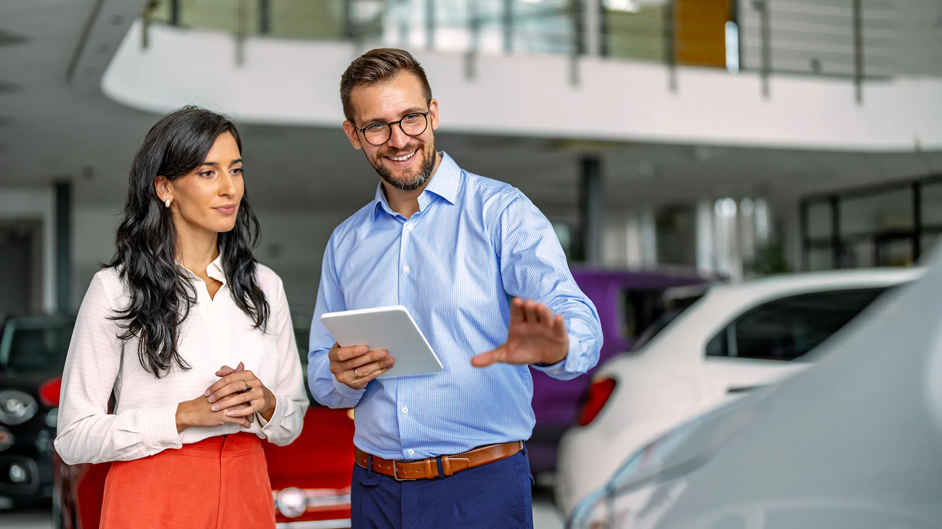 Ein Mann und ein Frau stehen vor einem Auto. 