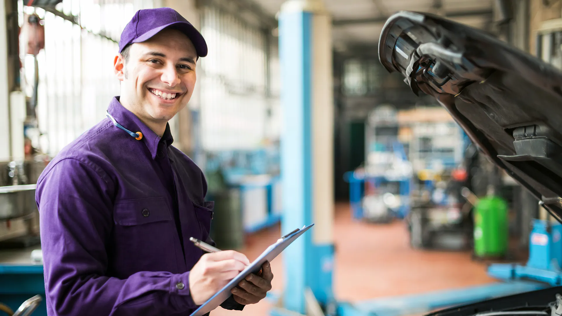 Service-Mitarbeiter steht vor einer offenen Motorhaube