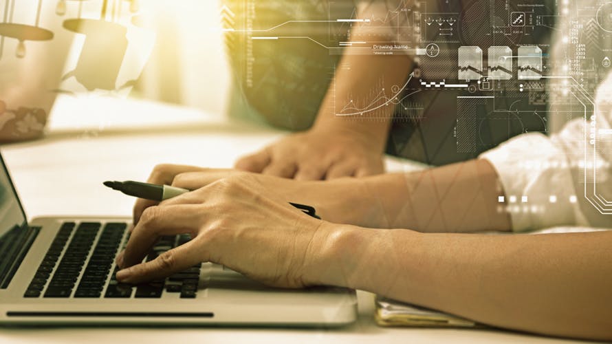 A pair of hands typing on a computer keyboard