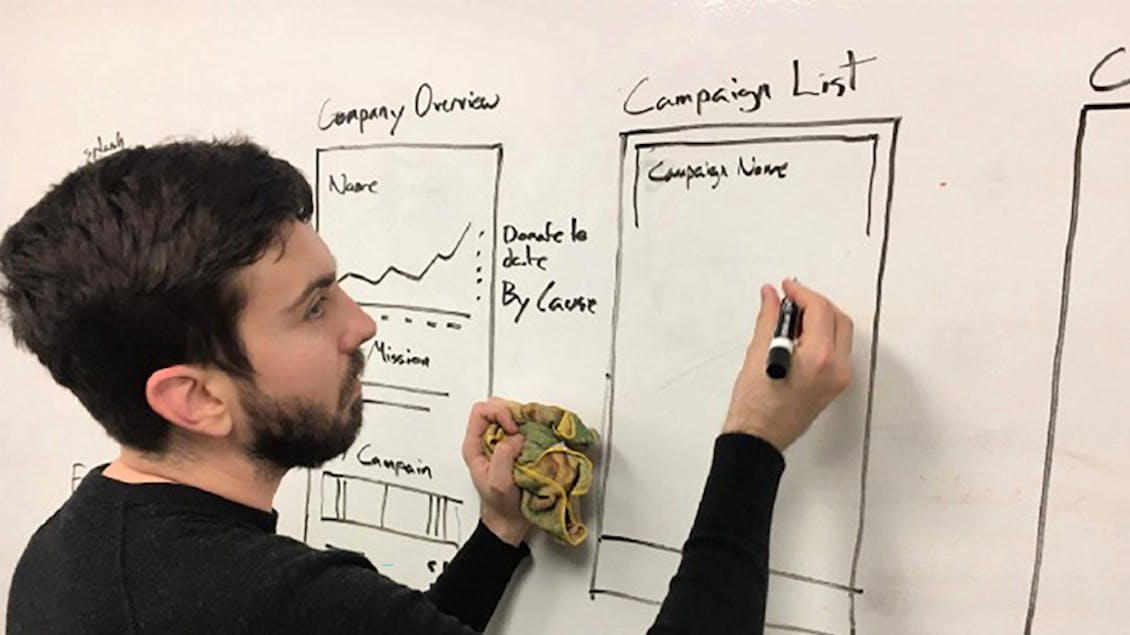 Nicholas drawing some wireframes on a white board