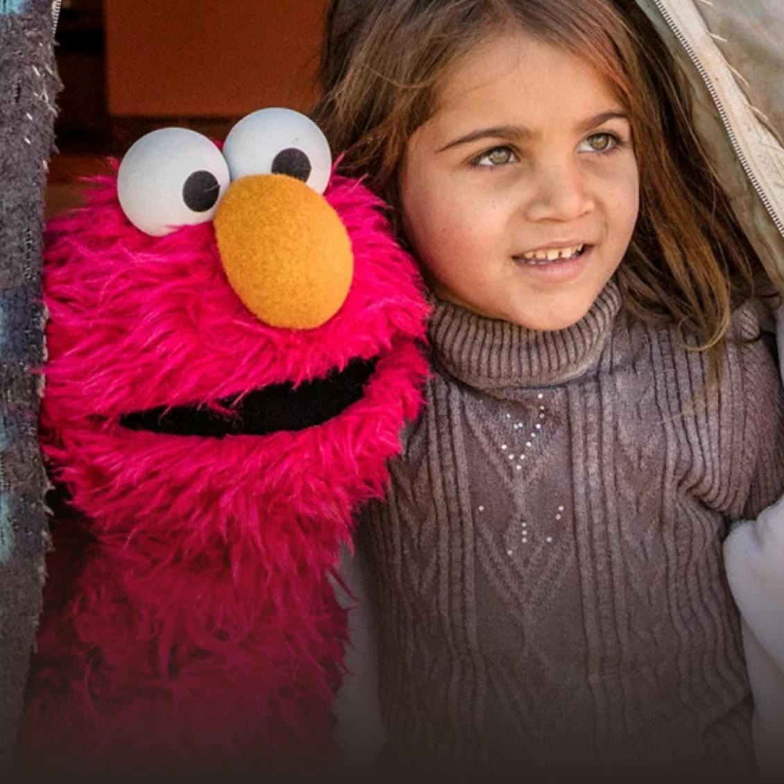 a kid getting a photo with Elmo