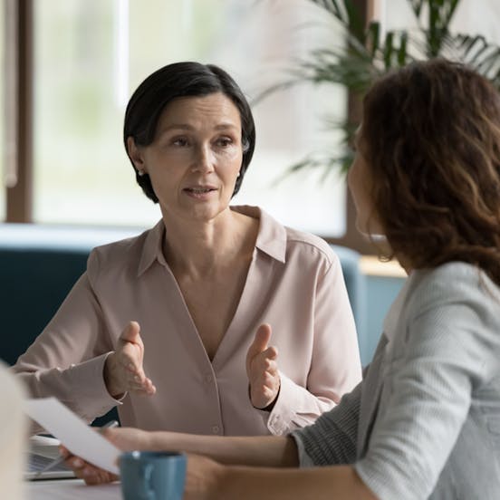 Two women speaking at a table