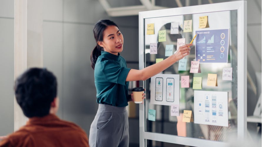 UX developer and ui designer presenting mobile app interface design on whiteboard