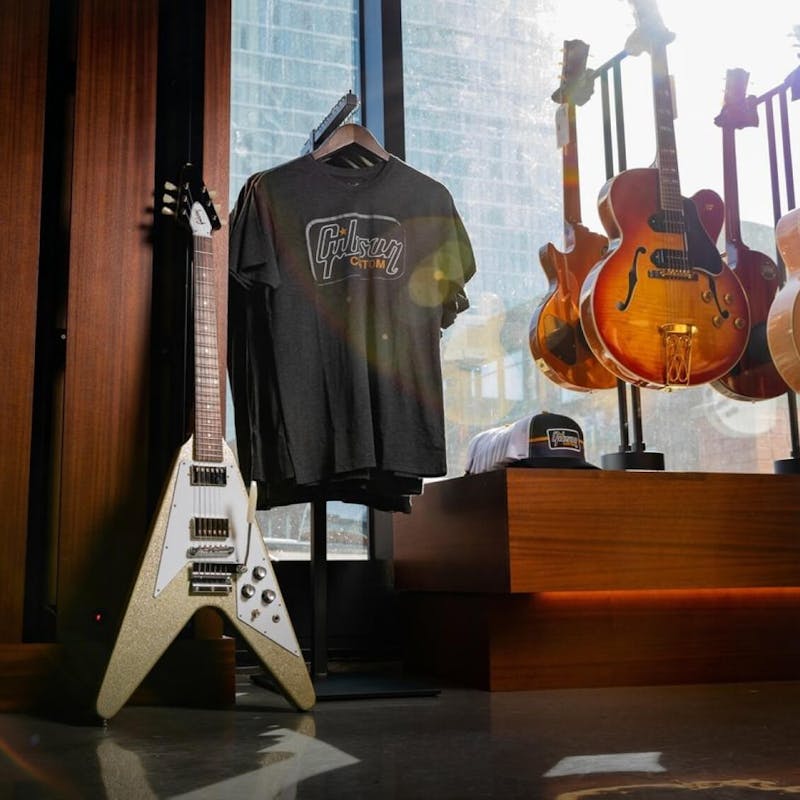 Gibson guitar with band tee behind
