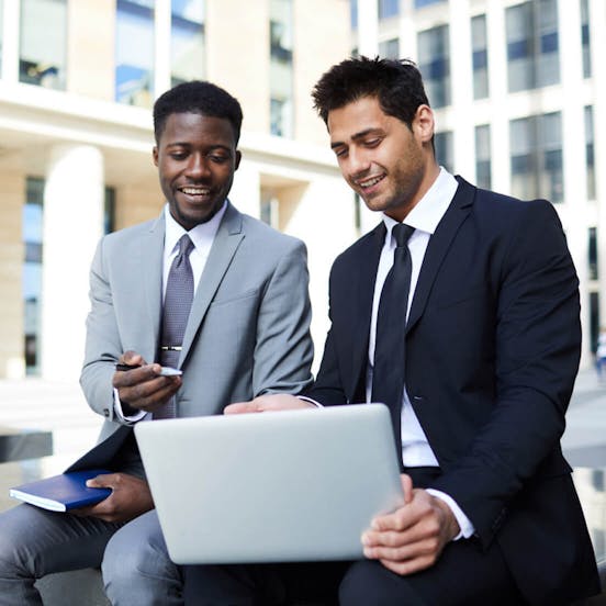 Two business men looking down at a laptop