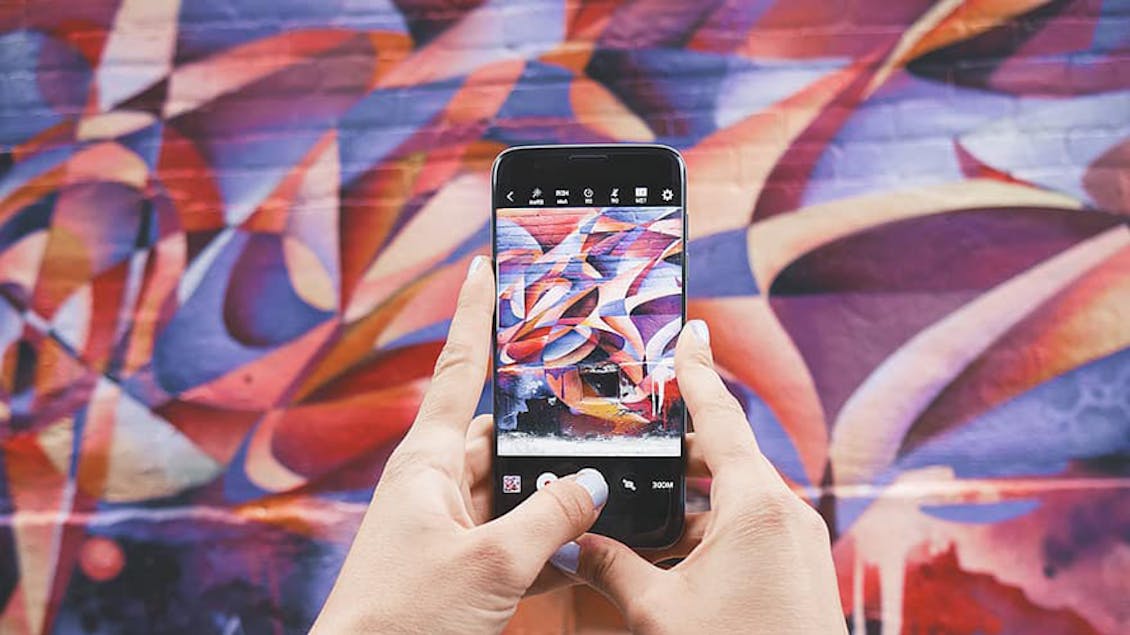 A woman taking a photo of a graffiti