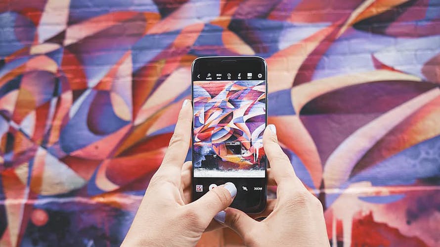 A woman taking a photo of a graffiti