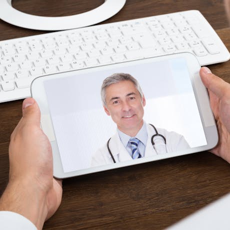 a man looking on a video call with his doctor