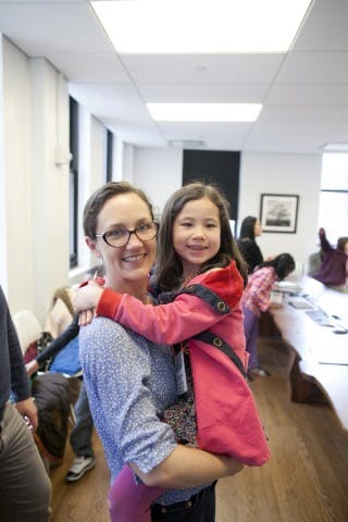 Kristin Vogel, holding a smilling kid