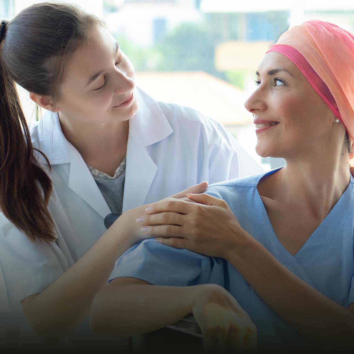 Chemotherapy patient and doctor smiling at each other
