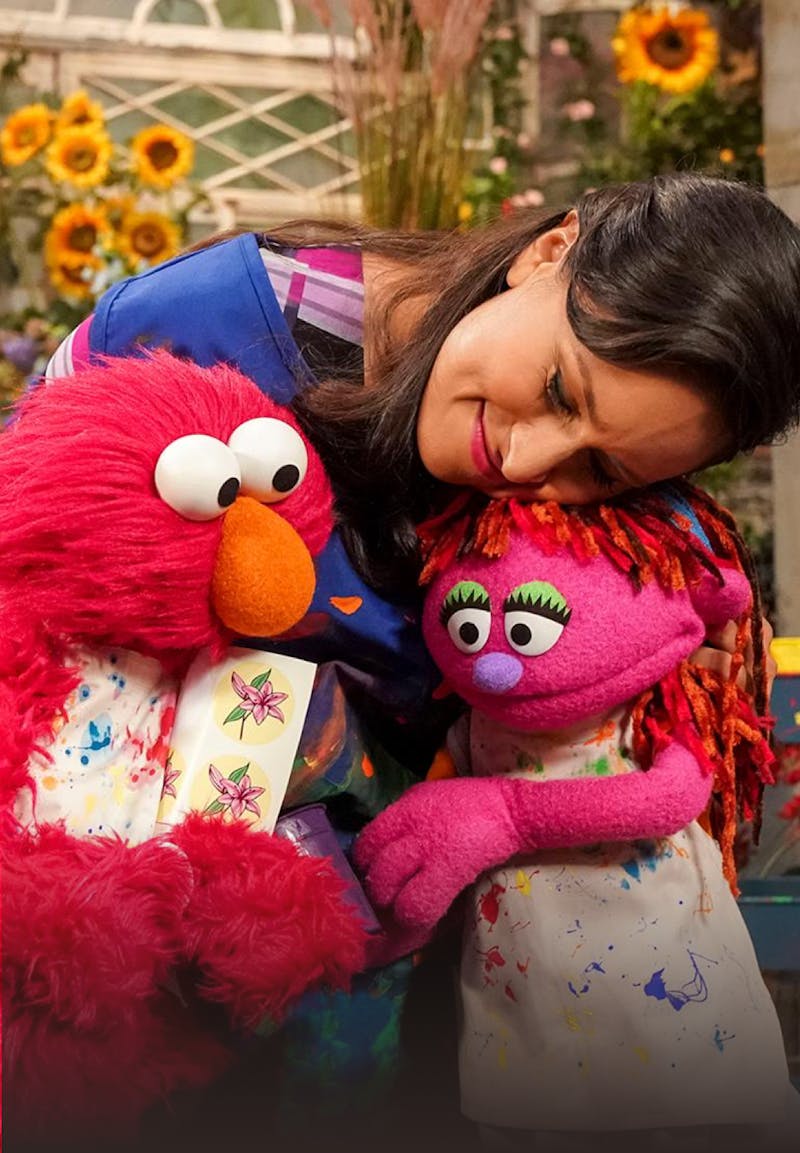 a woman hugging Elmo and Abby Cadabby