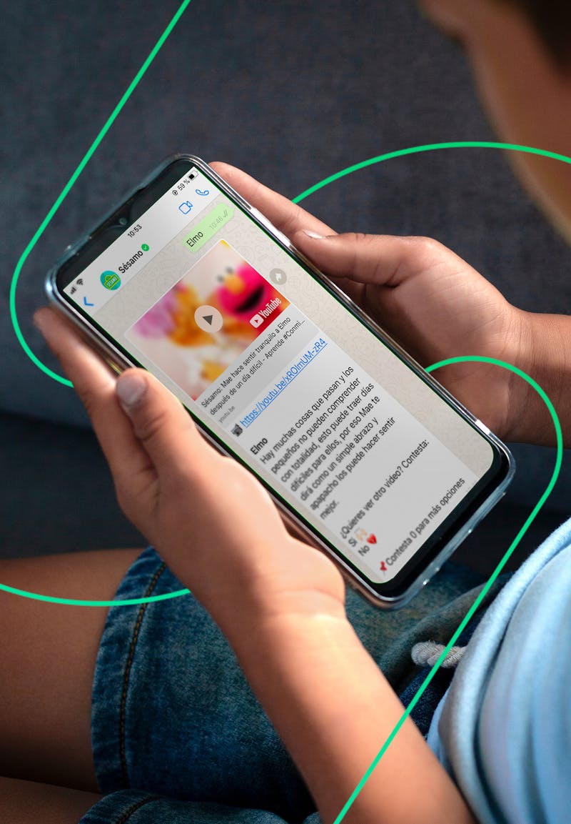 Kid holding a phone with the Sesame Workshop Whatsapp experience