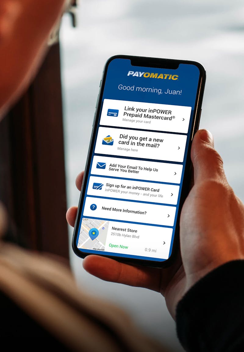 Hand holding phone showing Payomatic on screen 