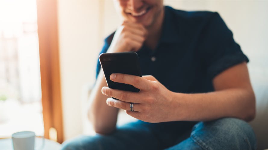 a man looking at his phone smilling