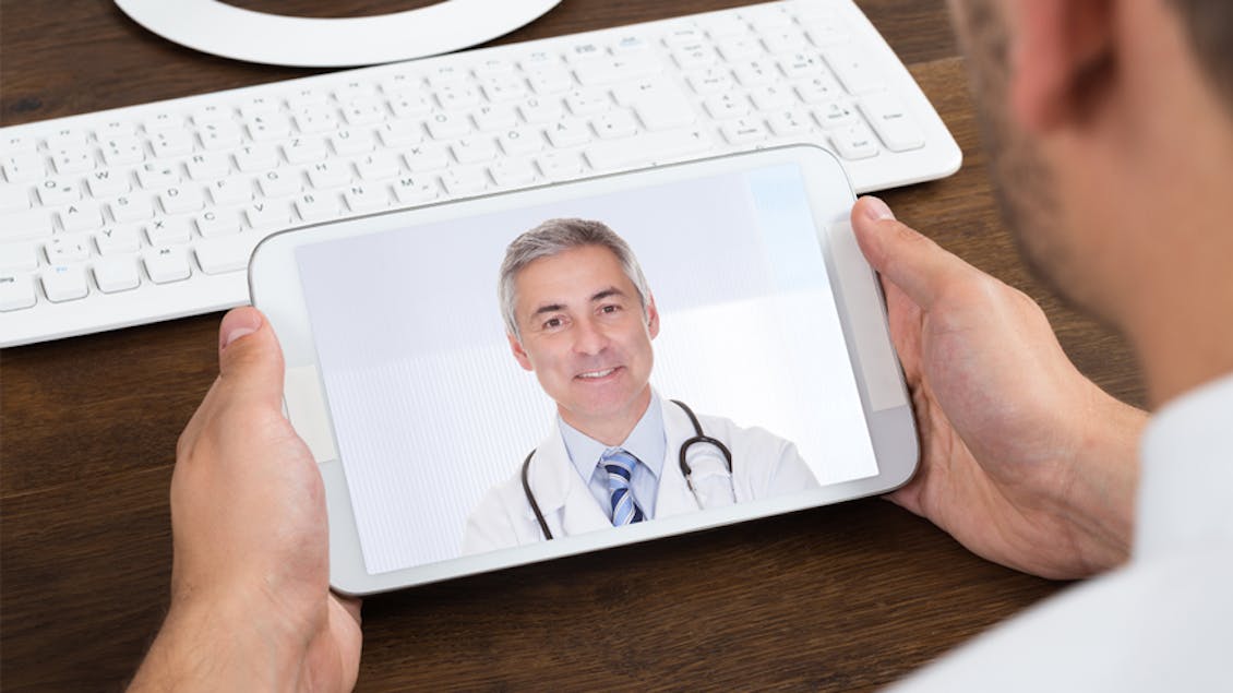 a man looking on a video call with his doctor