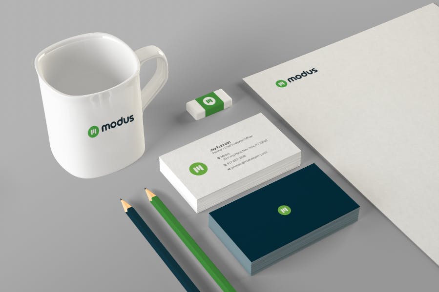Mockup of the new Modus logo on a coffee mug and stationary.
