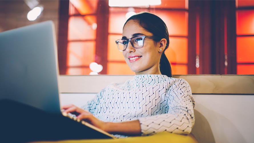 A woman looking at her computer smiling