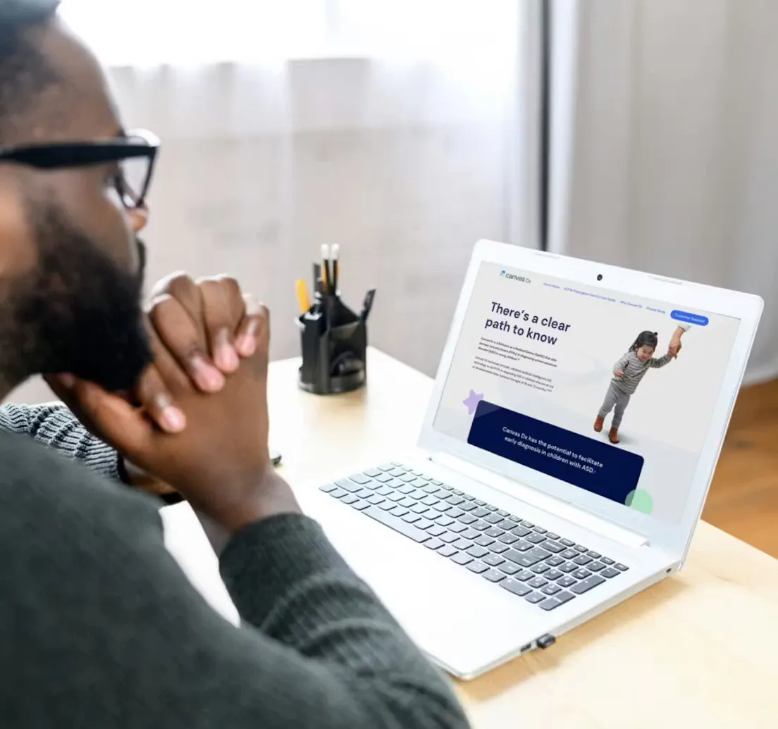 Man with glasses looking at a laptop