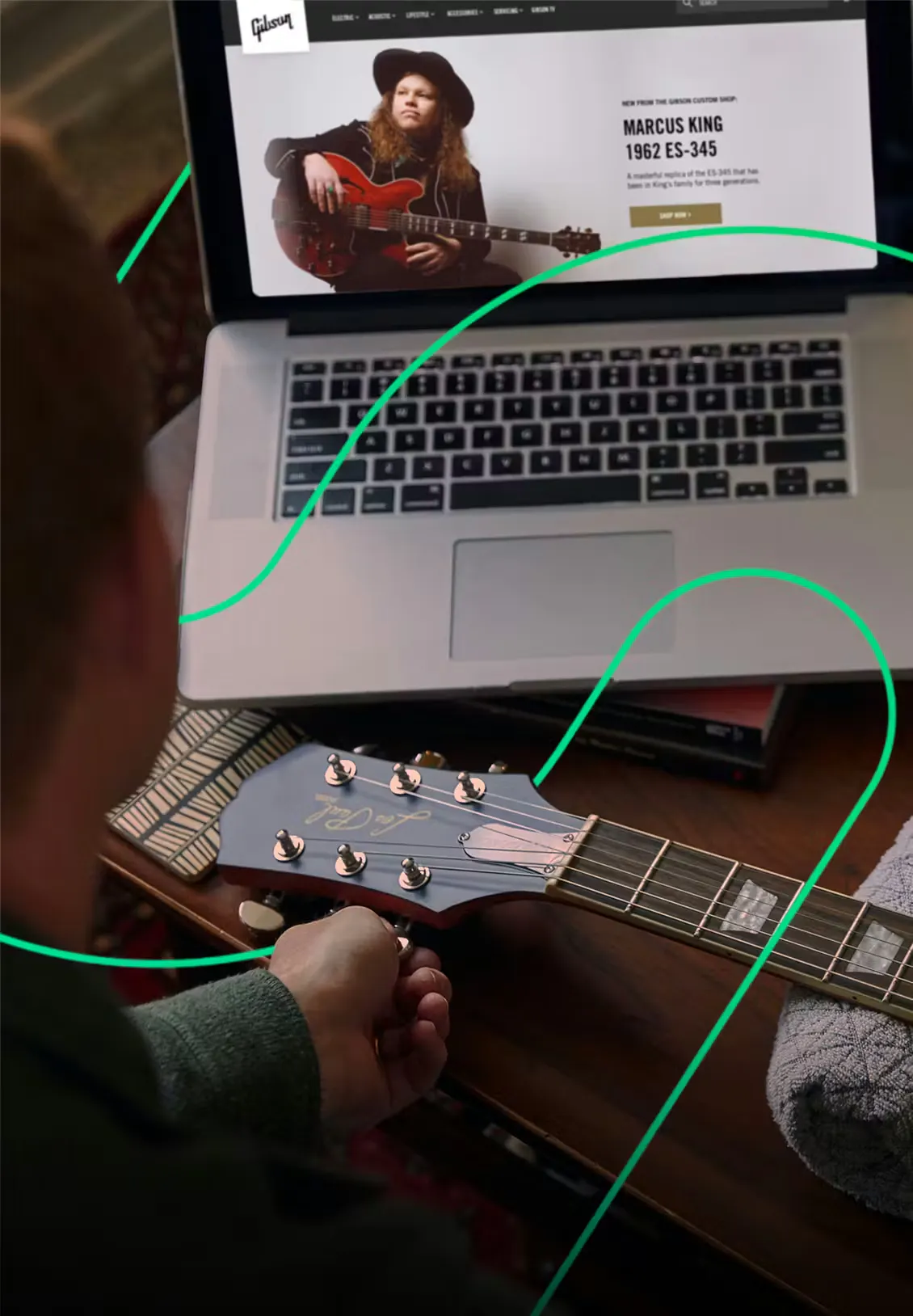 retail experience at Gibson.com on a laptop with a hand holding a guitar