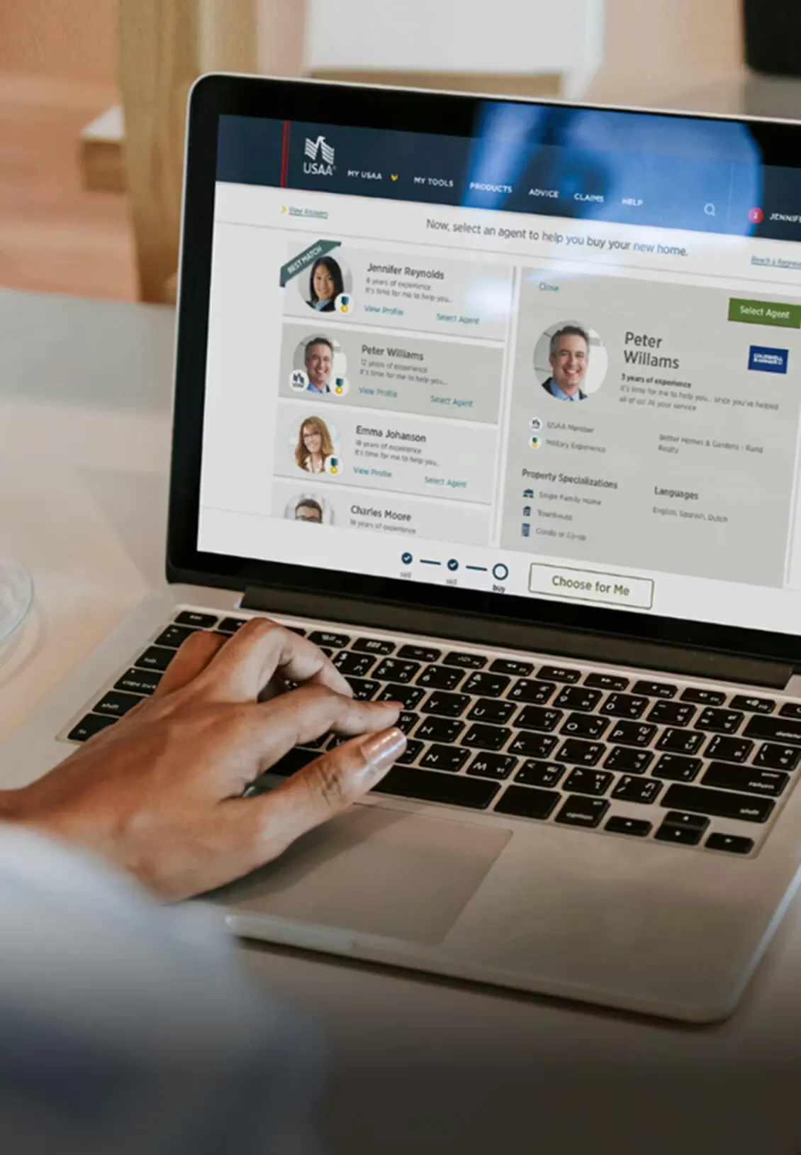 a hand using a laptop with one of the USAA site screens