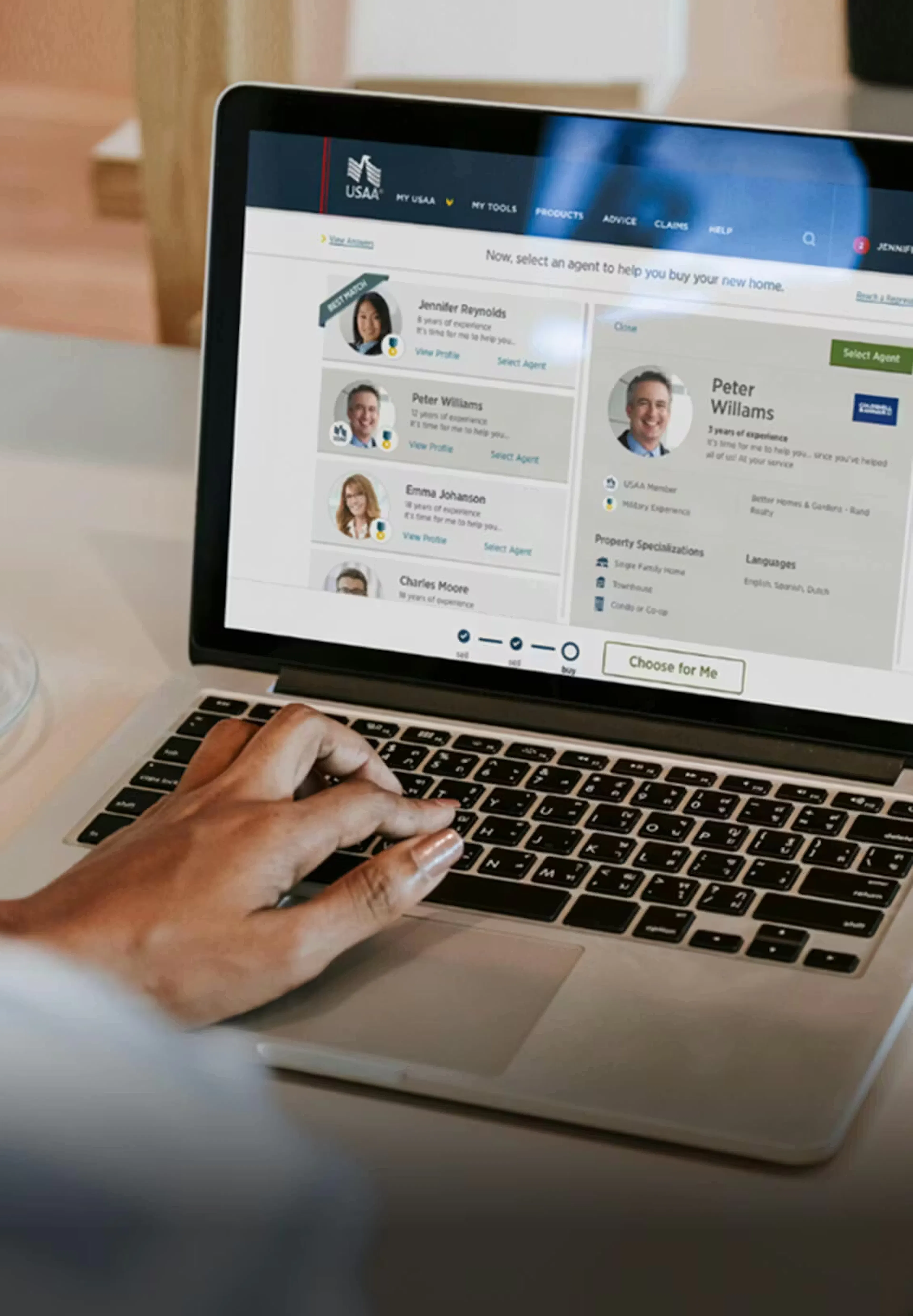 a hand using a laptop with one of the USAA site screens