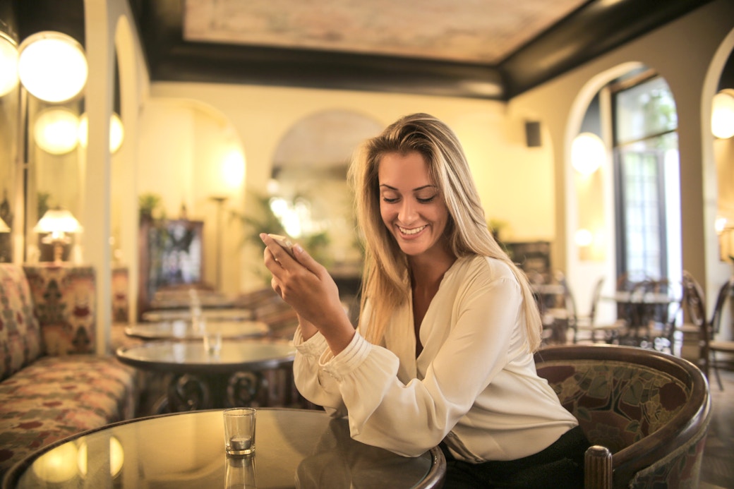 a girl laughing while drinking her coffee