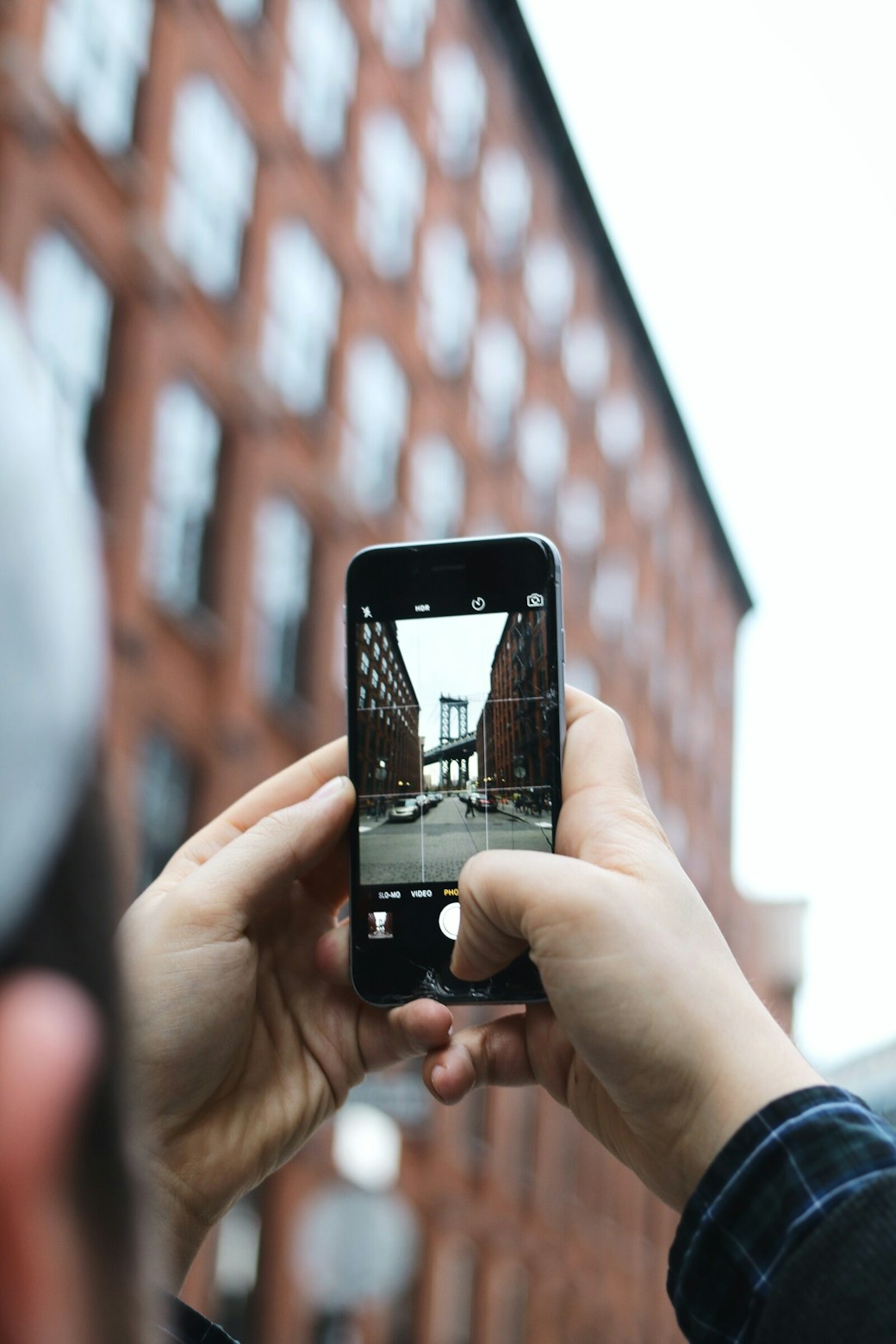 a girl taking a picture of a building in the city