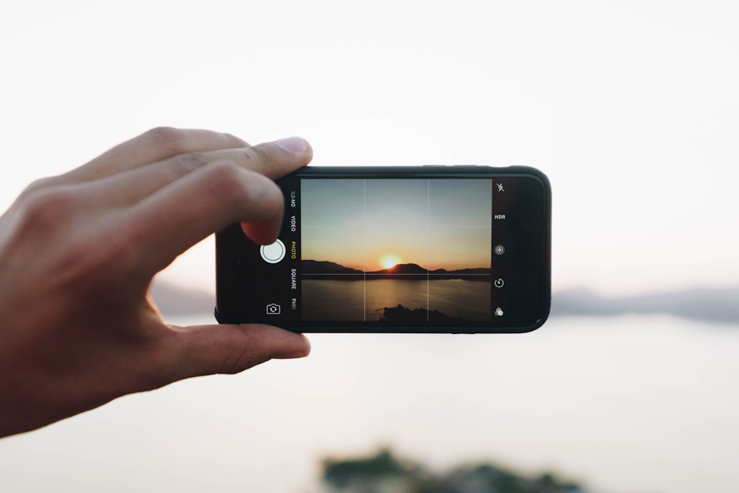 a girl taking a picture of a landscape