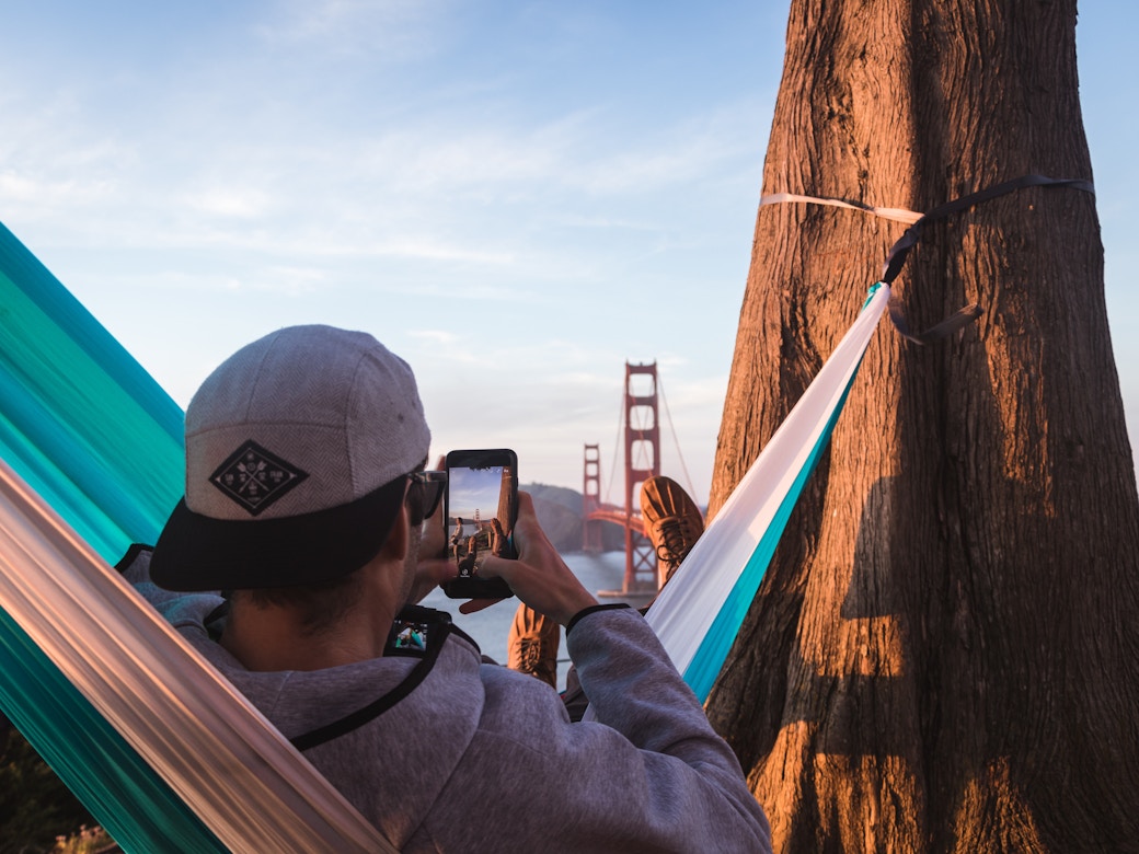 Man in hammock taking photo