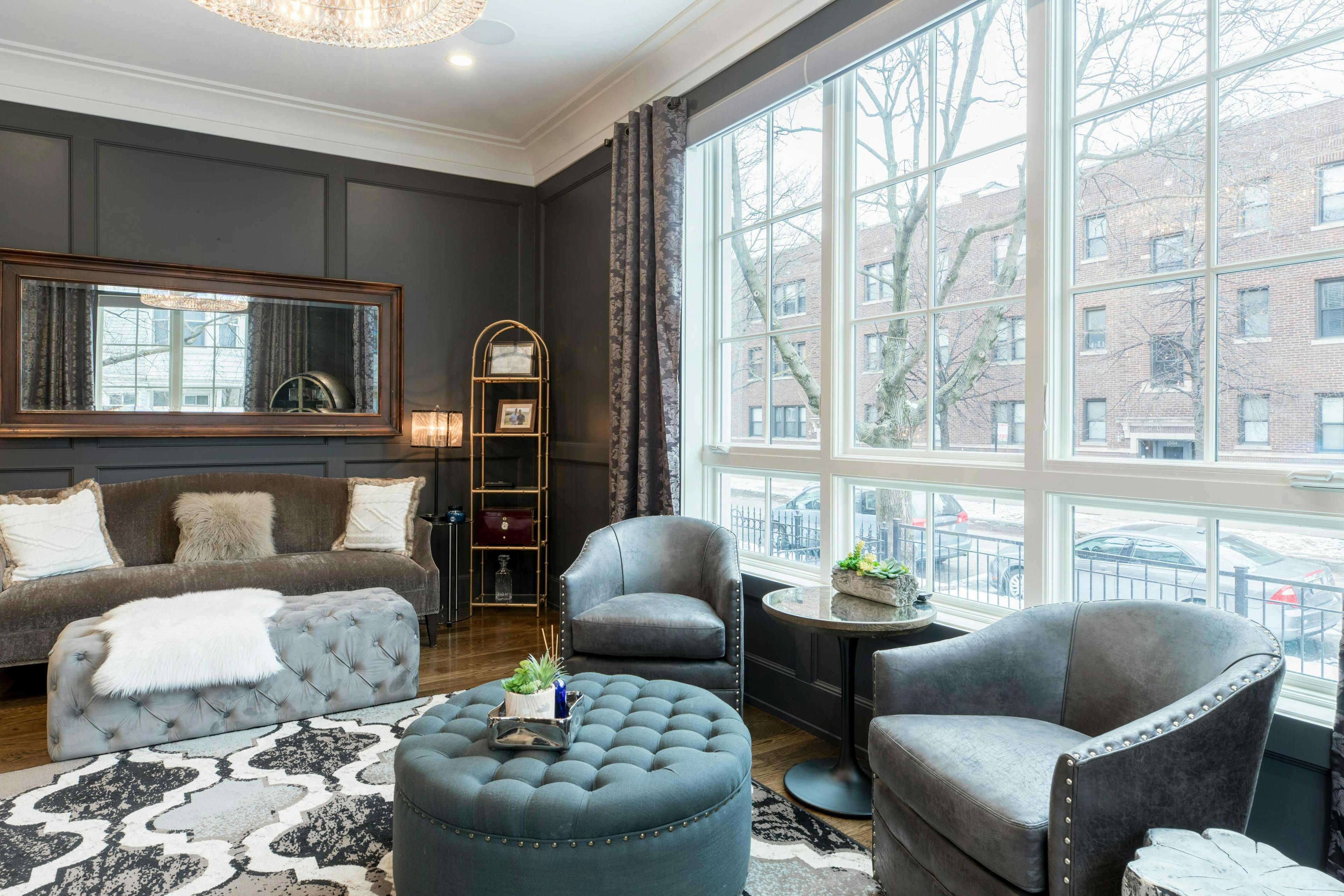 classic design of the living room with big windows, mirror and vintage green furniture