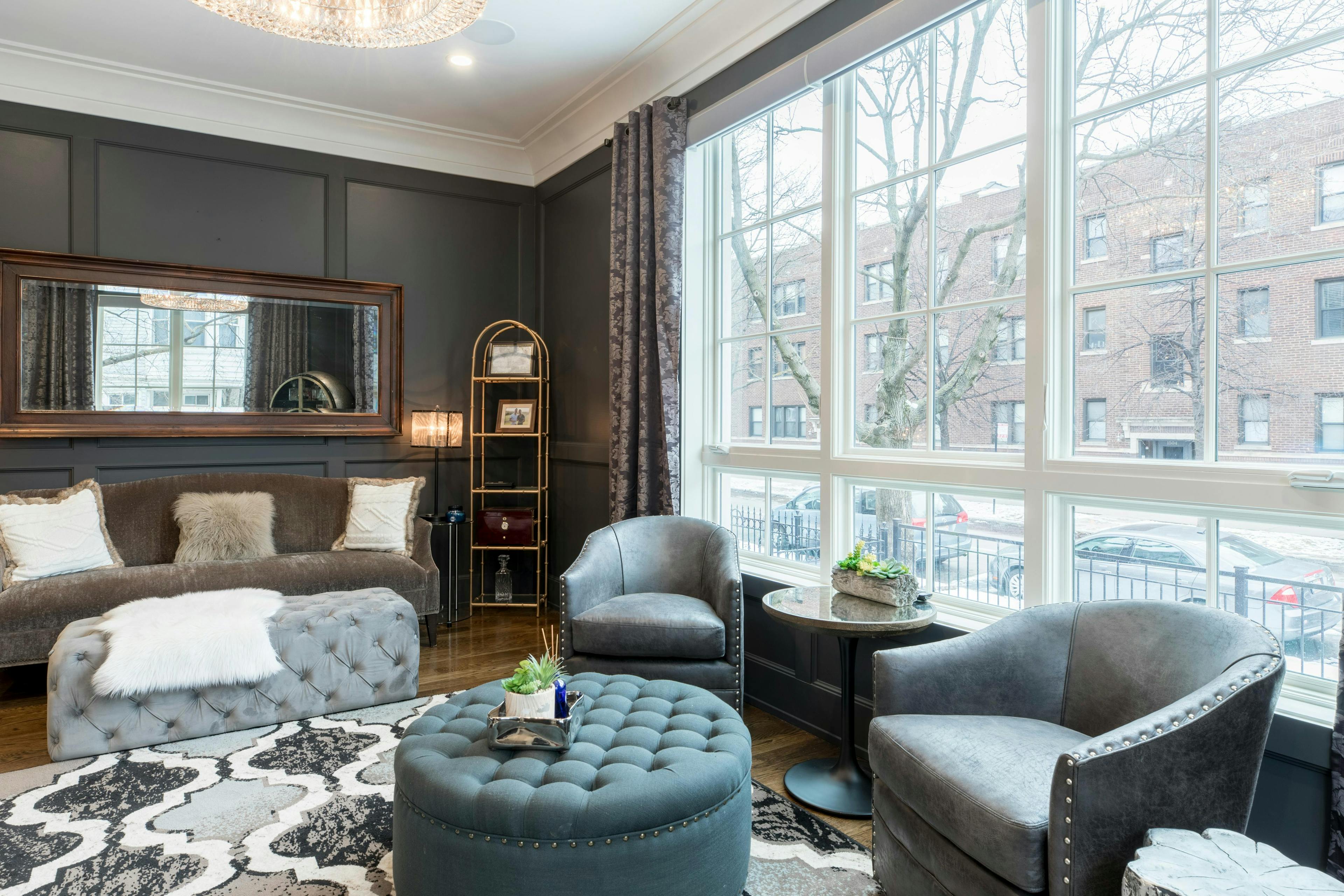 classic design of the living room with big windows, mirror and vintage green furniture 