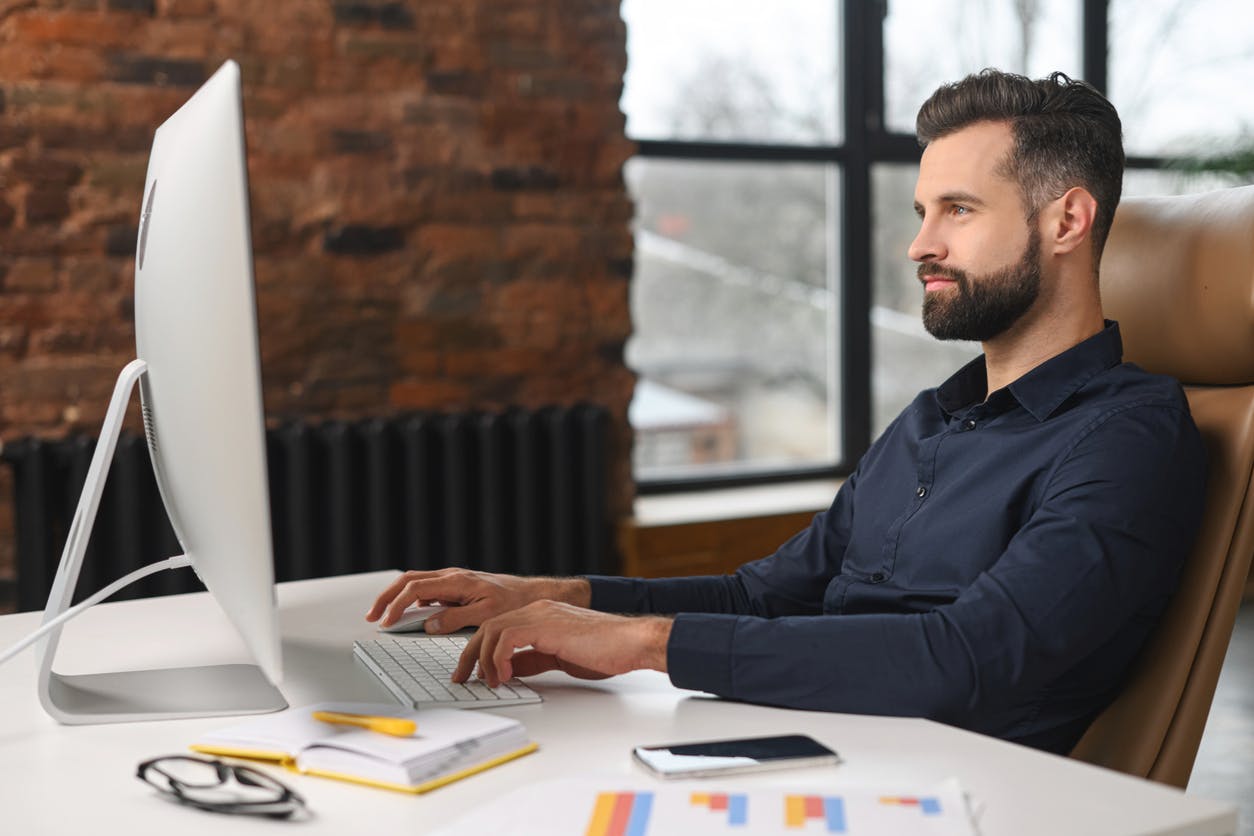 homme en train de travailler sur un ordinateur sur une plateforme en ligne