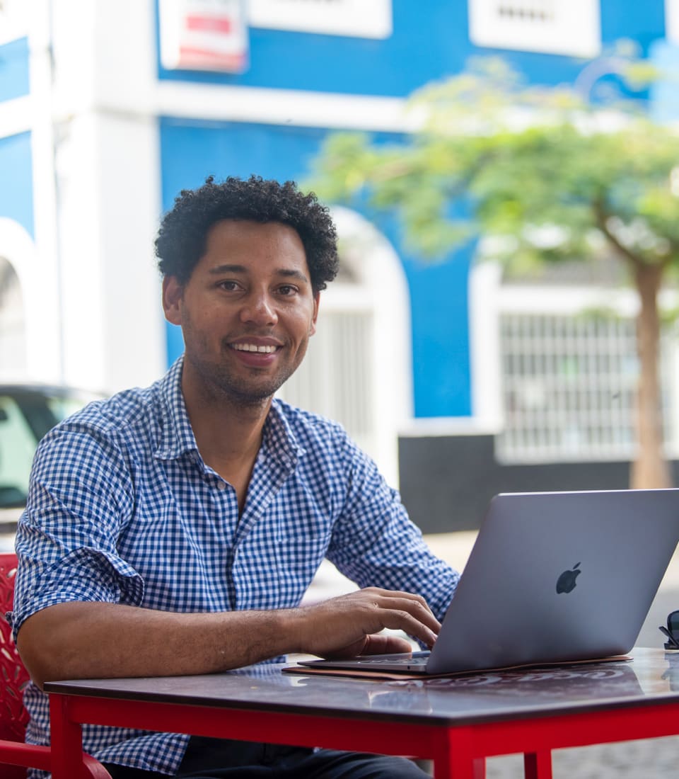 Joshua kijkt in de camera van achter zijn laptop
